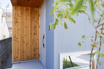 明るいグレーの外壁に板張りのアクセント